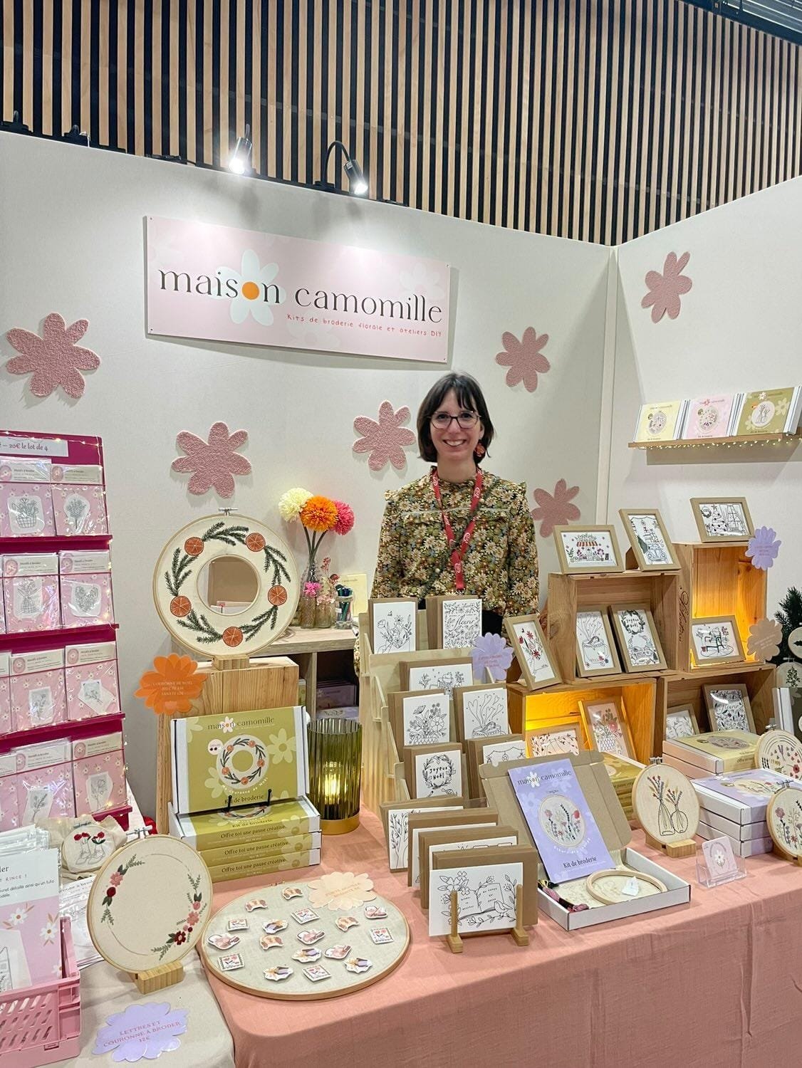 Créatrice derrière son stand en salon créatif à Paris
